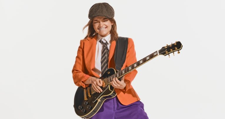 Teenage girl posing dramatically with an electric guitar