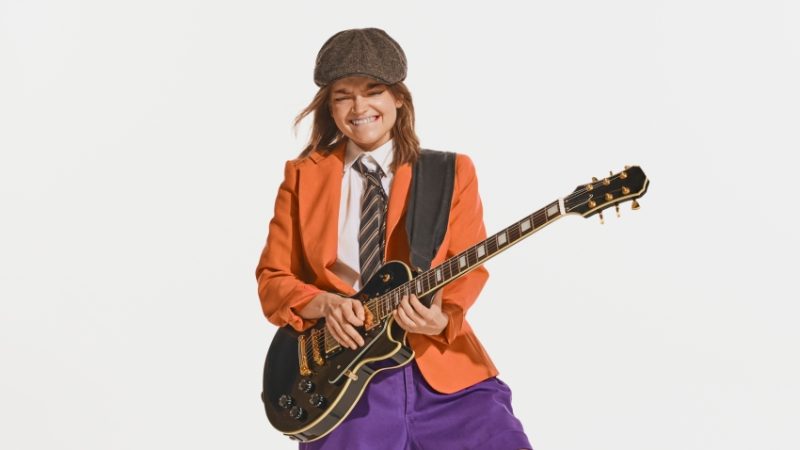 Teenage girl posing dramatically with an electric guitar