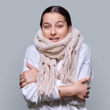 Photo of a visibly cold teenage girl wearing a scarf