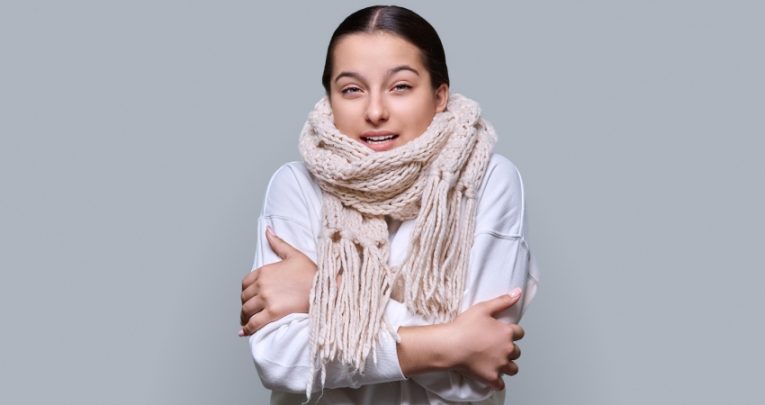 Photo of a visibly cold teenage girl wearing a scarf