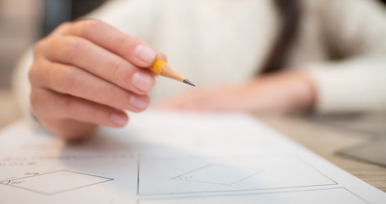 extreme close-up on a child's hand filling out a test paper