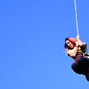 photograph of teenage girl hanging from a bungee rope