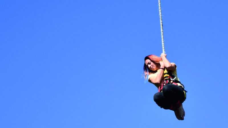 photograph of teenage girl hanging from a bungee rope