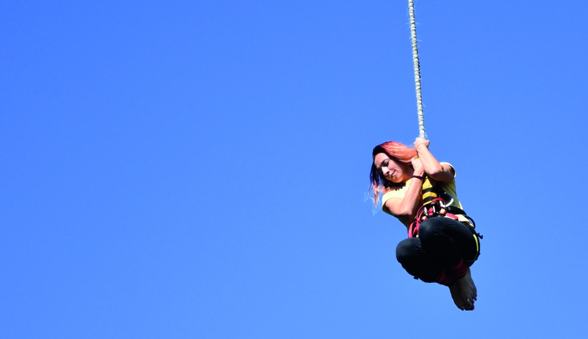 photograph of teenage girl hanging from a bungee rope