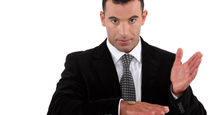 close-up photo of main in suit tossing a coin