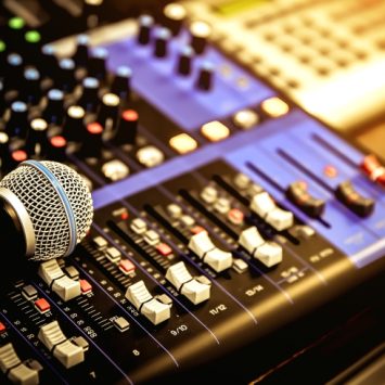 close-up photo of studio equipment including a microphone and mixing desk