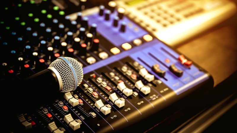 close-up photo of studio equipment including a microphone and mixing desk