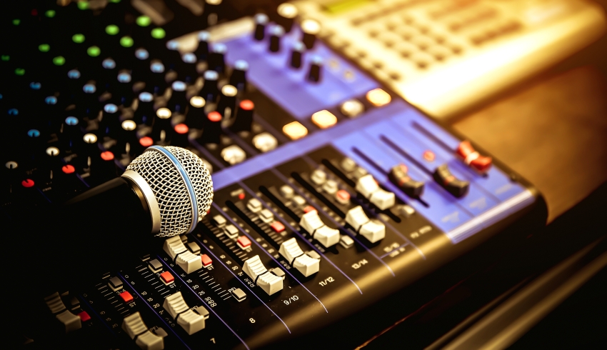 close-up photo of studio equipment including a microphone and mixing desk