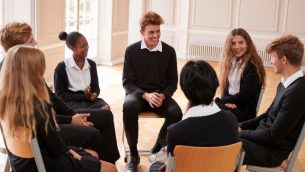 photo of teenage school students engaged in a group discussion, representing RSE curriculum