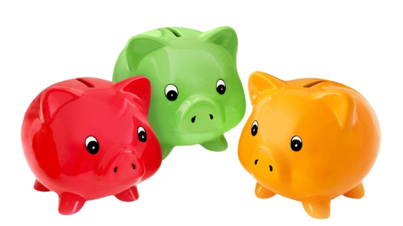 close-up photo of three differently-coloured children's piggy banks representing paying for extracurricular activities