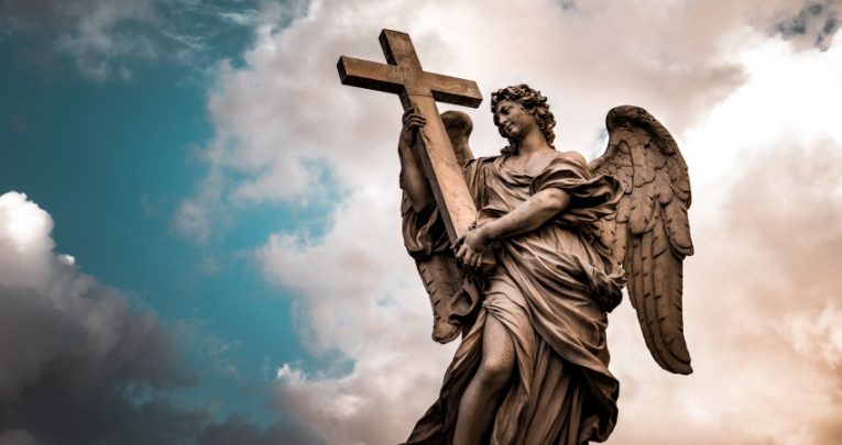 Photo of an angel statue against a dark, cloudy sky