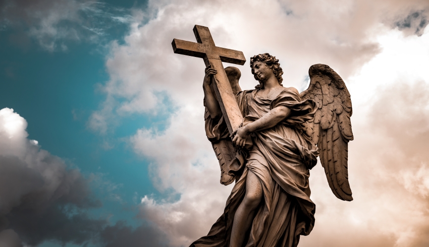 Photo of an angel statue against a dark, cloudy sky