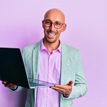 photo of friendly teacher trainer holding up a laptop
