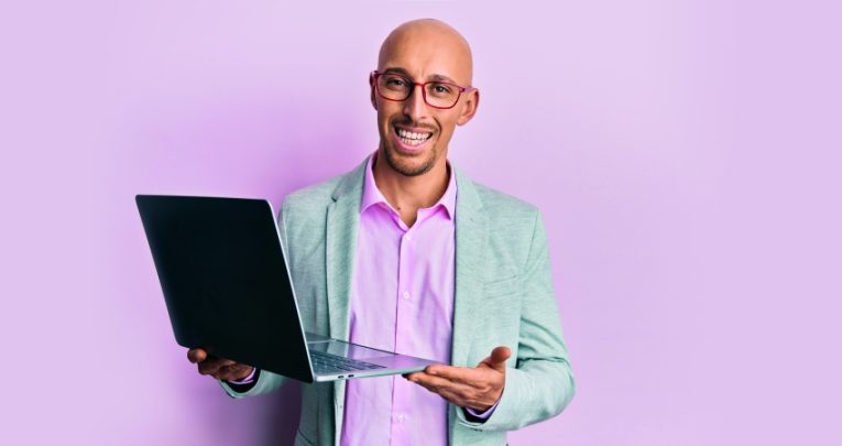 photo of friendly teacher trainer holding up a laptop