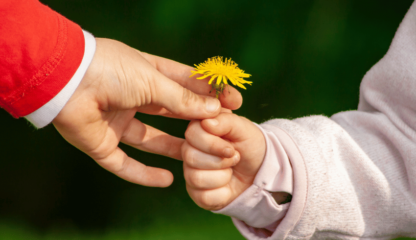 Child handing child a flower