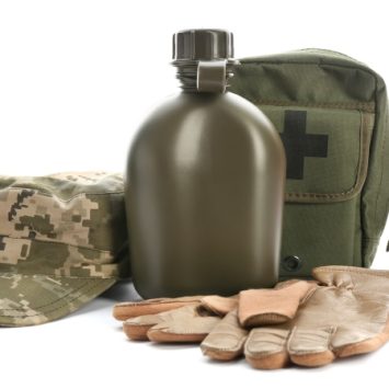 isolated photo of army equipment, including khaki cap, flask, first aid kit and gloves