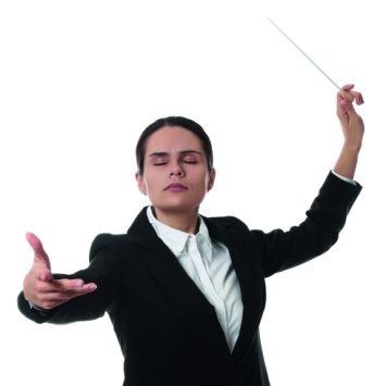photo of an orchestra conductor with eyes closed and baton raised
