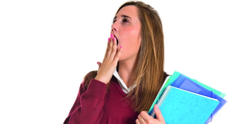 photo of teenage student holding folders and yawning