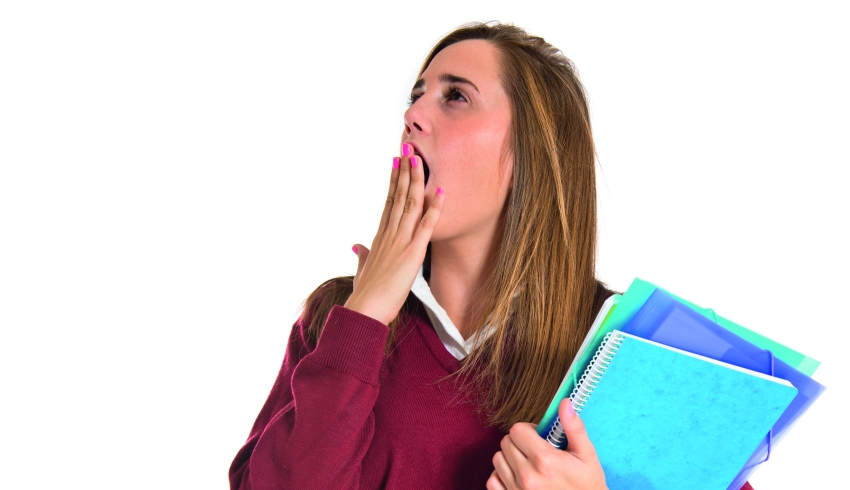 photo of teenage student holding folders and yawning