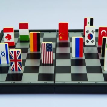 Abstract photo showing national flag playing pieces on a chessboard to illustrate concept of geopolitics