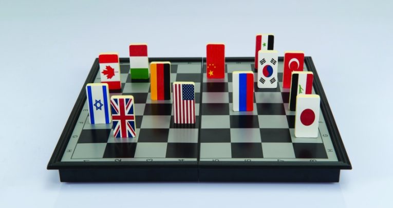 Abstract photo showing national flag playing pieces on a chessboard to illustrate concept of geopolitics