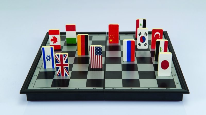 Abstract photo showing national flag playing pieces on a chessboard to illustrate concept of geopolitics