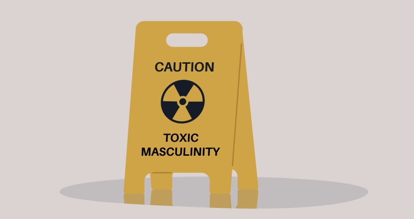 Mock-up illustration of a yellow wet floor warning sign that reads 'caution - toxic masculinity', representing misogyny in schools