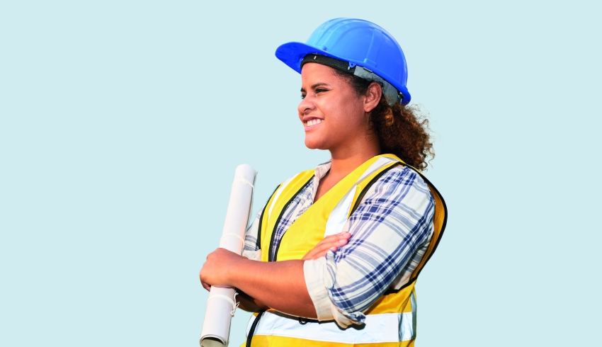 photo of a teenage girl wearing a high-vis vest and hard hat while holding a set of blueprints, representing women in STEM