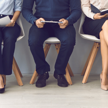 Body and legs of people waiting for interview, representing teacher interview questions