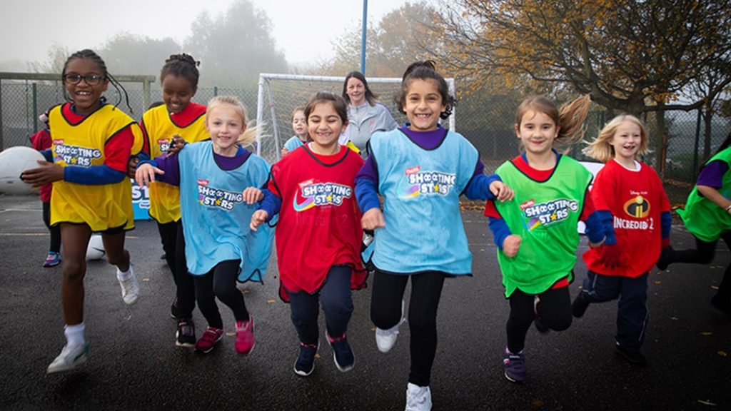 Girls outside in colourful bibs, inspired by World Cup 2026