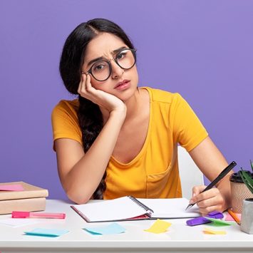 Photo of girl studying at desk, looking anxious
