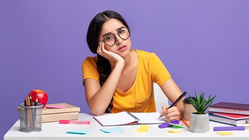 Photo of girl studying at desk, looking anxious