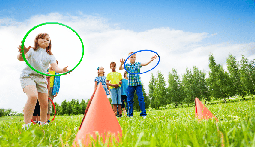 Children throwing hoops in adverbs lesson