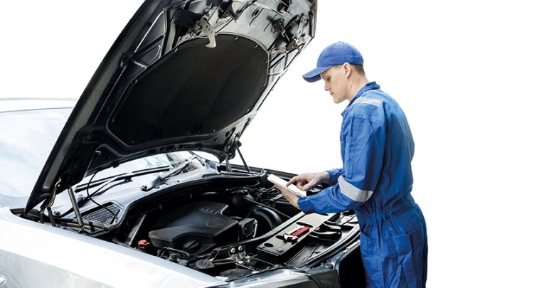 Photo of a car mechanic inspecting a car engine, representing teaching English