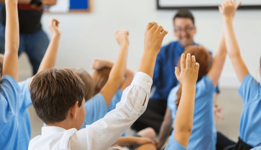 Pupils following school rules by putting their hands up