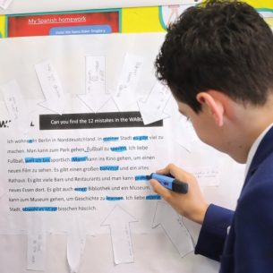 Photo of two teenage students completing a practical activity using a resource contained within a classroom display