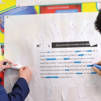 Photo of two teenage students completing a practical activity using a resource contained within a classroom display