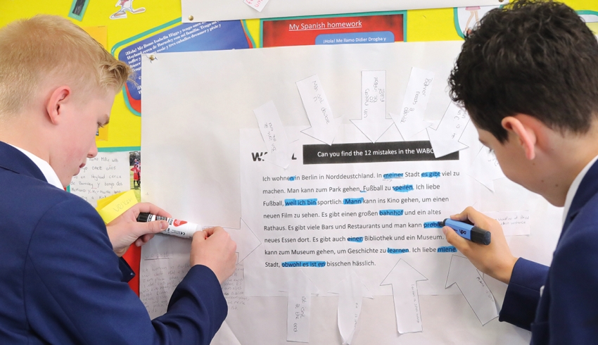Photo of two teenage students completing a practical activity using a resource contained within a classroom display