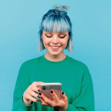 Brightly coloured photo of teenage girl happily using a smartphone
