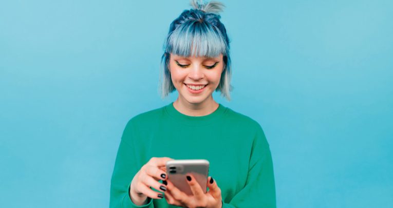 Brightly coloured photo of teenage girl happily using a smartphone