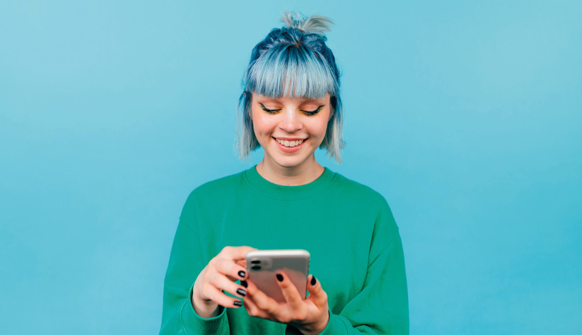 Brightly coloured photo of teenage girl happily using a smartphone