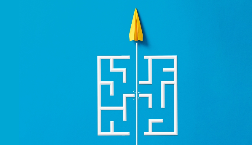 Abstract illustration of a paper aeroplane breaking through a simple wooden labyrinth, representing lesson difficulty