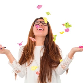 Photo of teenage girl throwing Post-it notes, representing GCSE revision