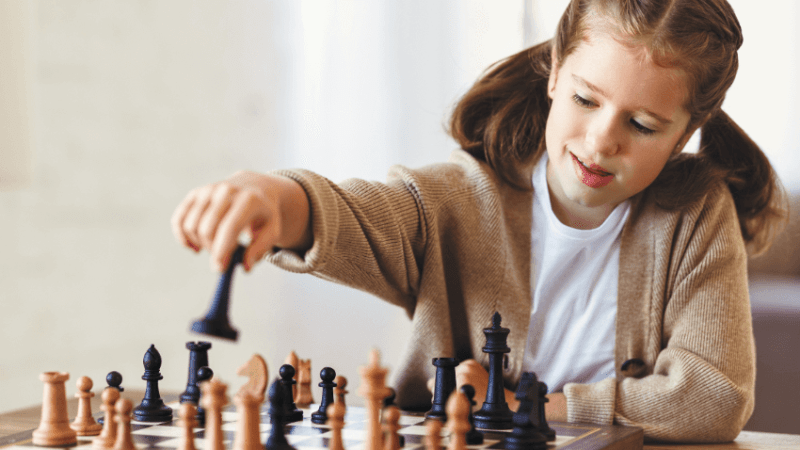 Young white girl playing chess