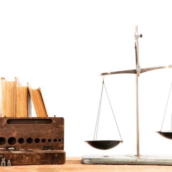 Photo of weighing scales beside a set of books to convey notion of justice