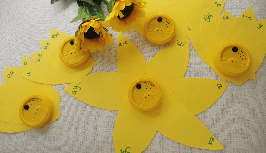'Flower' for teaching phonics. Yellow paper petals with letters written on the tips; talking tins make the center of the 'flowers'