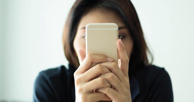 Photo of woman using a smartphone with her face conceal to illustrate notion of parental complaints