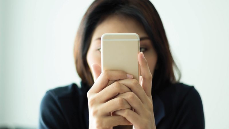 Photo of woman using a smartphone with her face conceal to illustrate notion of parental complaints