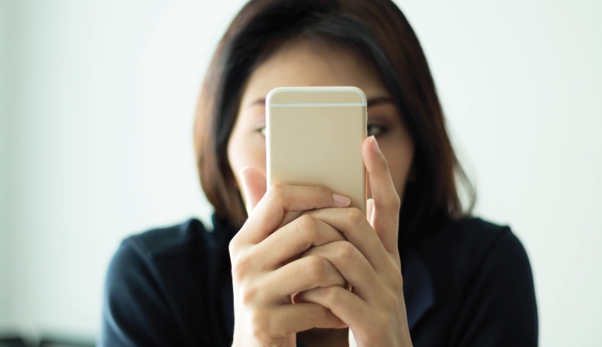 Photo of woman using a smartphone with her face conceal to illustrate notion of parental complaints