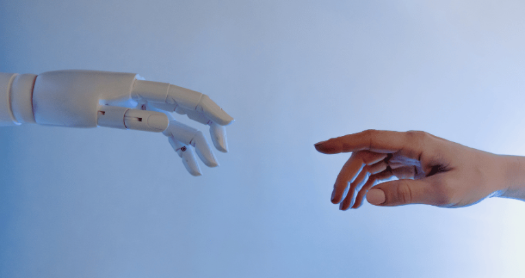 Human hand and robot hand reaching out to each other, representing AI in education